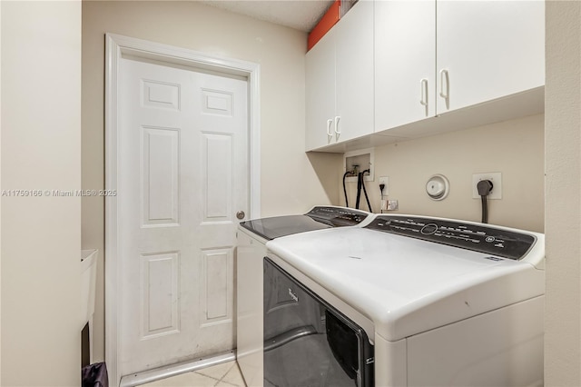 clothes washing area with cabinet space, independent washer and dryer, and light tile patterned floors