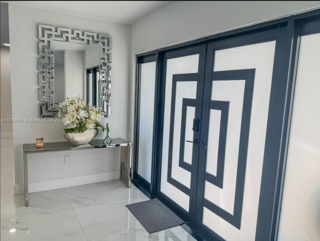 entryway featuring marble finish floor, french doors, and baseboards