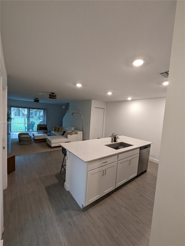 kitchen featuring visible vents, dishwasher, open floor plan, white cabinetry, and a sink