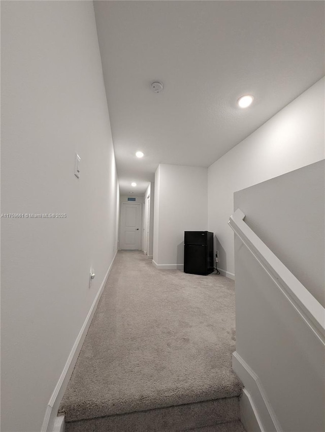 hallway featuring recessed lighting, baseboards, and light colored carpet