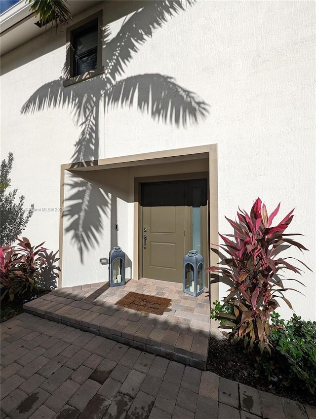 property entrance with stucco siding