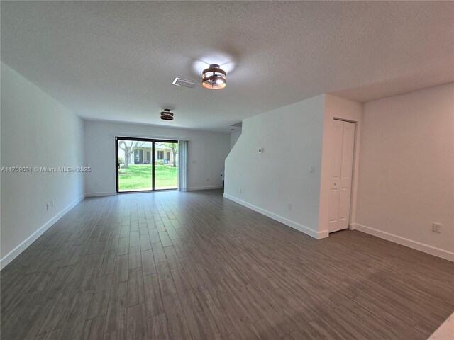 6001 Woods Edge Cir, Riviera Beach, FL 33410 - unfurnished room with dark wood-type flooring and a textured ceiling