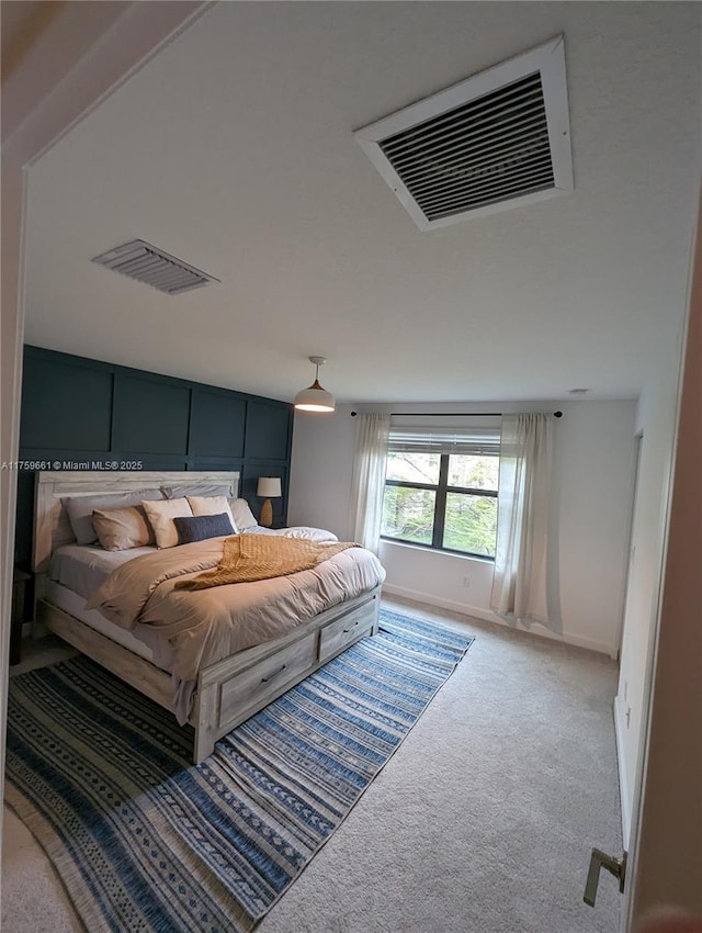 carpeted bedroom featuring visible vents and baseboards