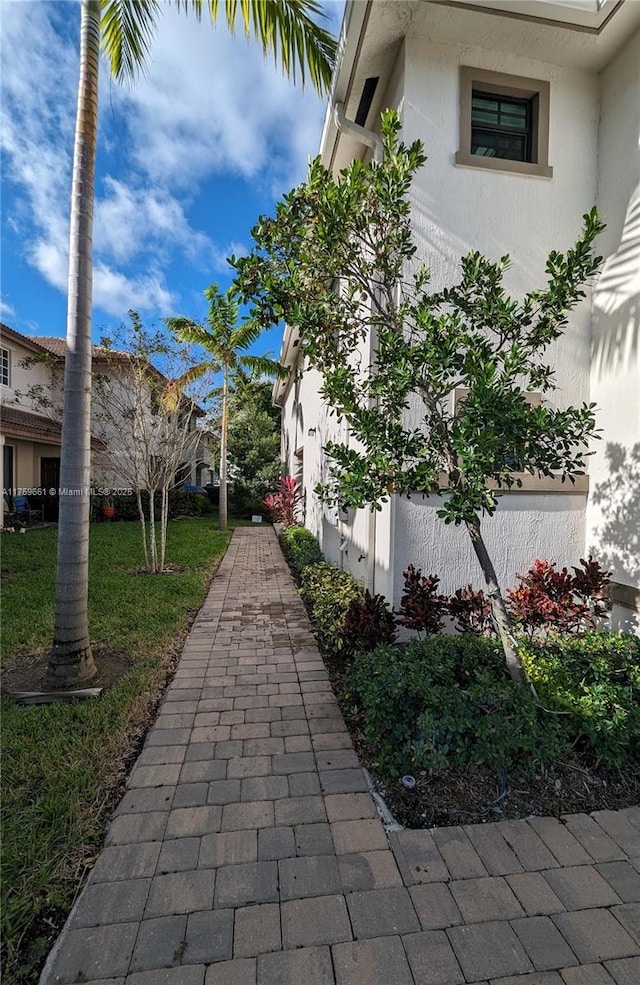 view of side of home with a yard and stucco siding