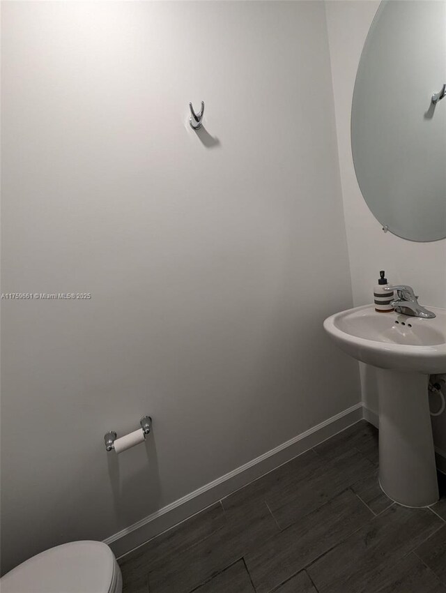 6001 Woods Edge Cir, Riviera Beach, FL 33410 - bathroom featuring wood tiled floors and toilet