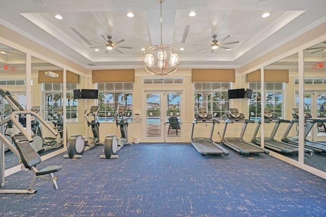 workout area with ceiling fan, a raised ceiling, crown molding, and french doors