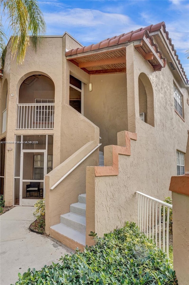 view of home's exterior featuring a tile roof and stucco siding