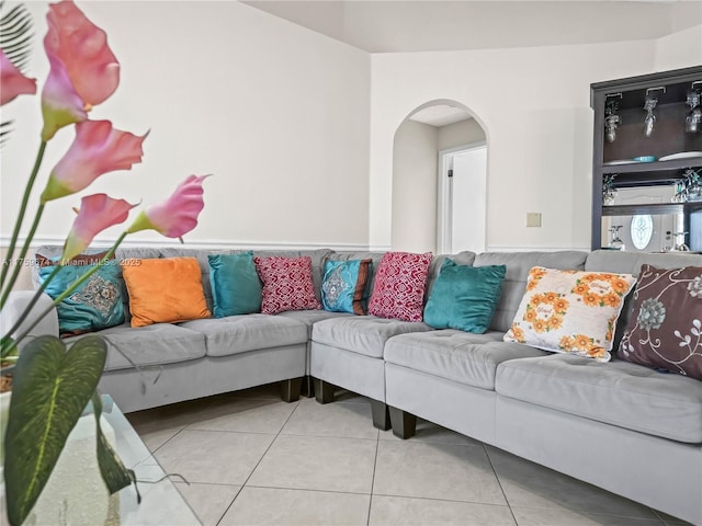 living room featuring arched walkways and tile patterned floors