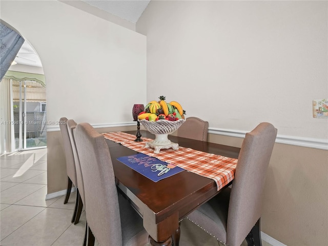 dining space featuring light tile patterned floors and baseboards