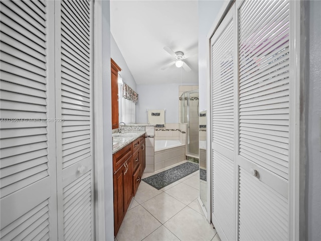 full bath with tile patterned floors, a garden tub, vanity, a shower stall, and a closet