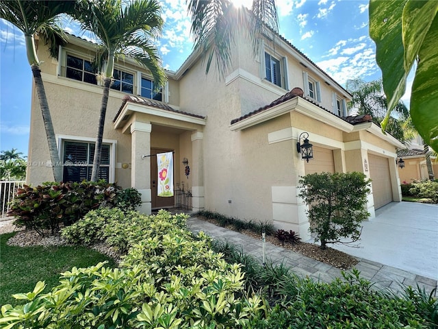 mediterranean / spanish house featuring stucco siding, driveway, and a garage