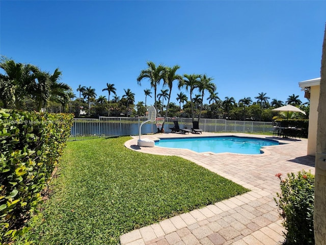 view of pool featuring a yard, a patio area, a fenced in pool, and fence