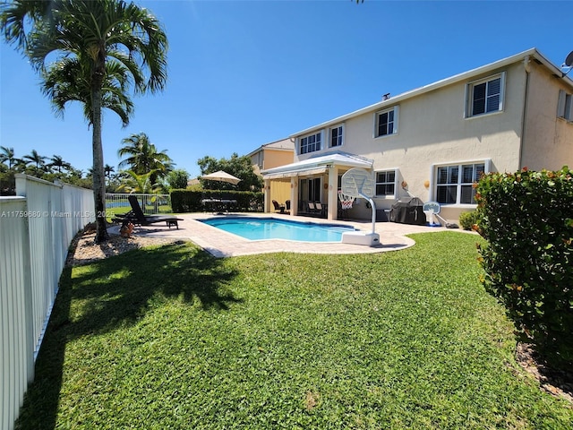 view of swimming pool with a yard, a patio, a fenced in pool, and a fenced backyard