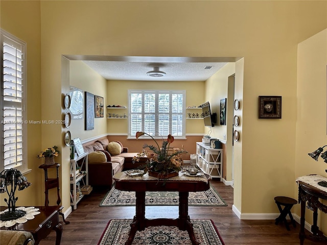 living room with visible vents, wood finished floors, baseboards, and a textured ceiling