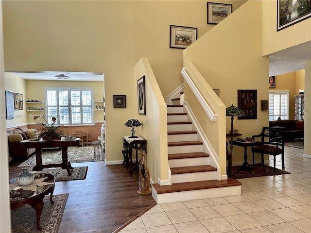 entrance foyer with a high ceiling, light tile patterned flooring, and a healthy amount of sunlight