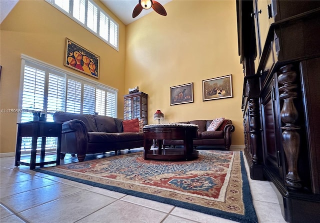 living room with baseboards, high vaulted ceiling, a ceiling fan, and tile patterned flooring