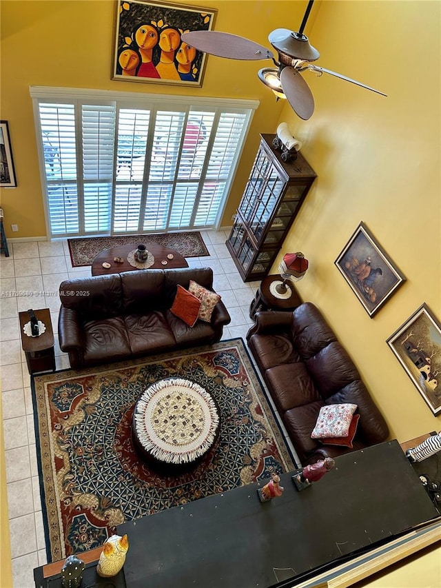 living room featuring a ceiling fan and tile patterned flooring