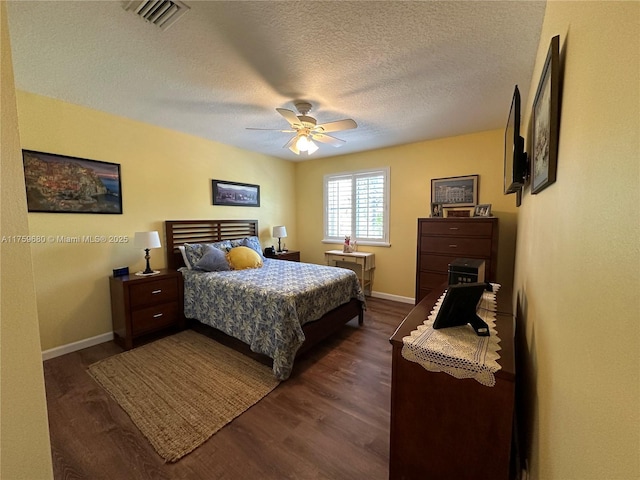 bedroom featuring visible vents, baseboards, dark wood-style floors, a textured ceiling, and a ceiling fan