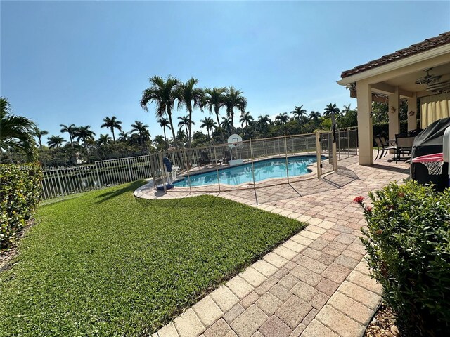 view of swimming pool with a patio, a lawn, a fenced in pool, and a fenced backyard