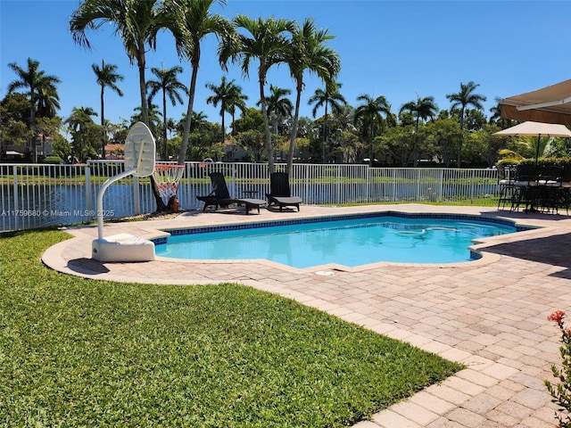 view of swimming pool featuring a patio, fence, a fenced in pool, and a lawn