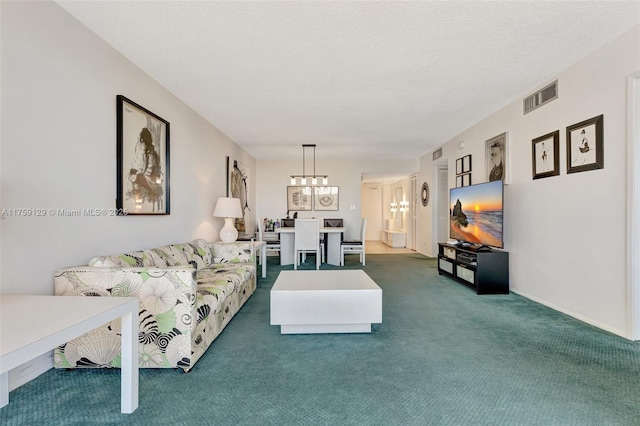 living area with a textured ceiling, dark colored carpet, a chandelier, and visible vents