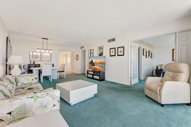 living area with carpet, visible vents, and a textured ceiling