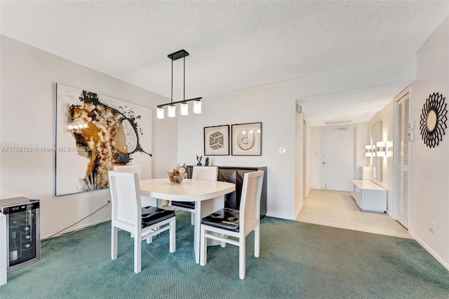 dining area with a textured ceiling, carpet floors, and beverage cooler