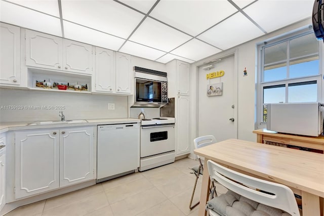 kitchen featuring white appliances, white cabinets, light countertops, open shelves, and a sink