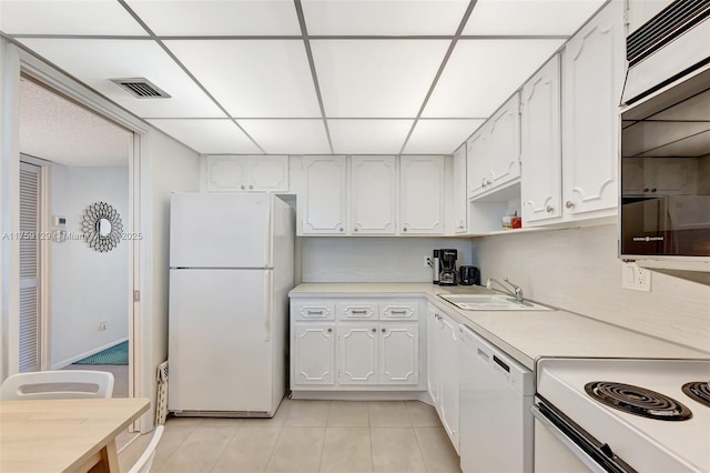 kitchen with white appliances, white cabinets, a sink, and light countertops