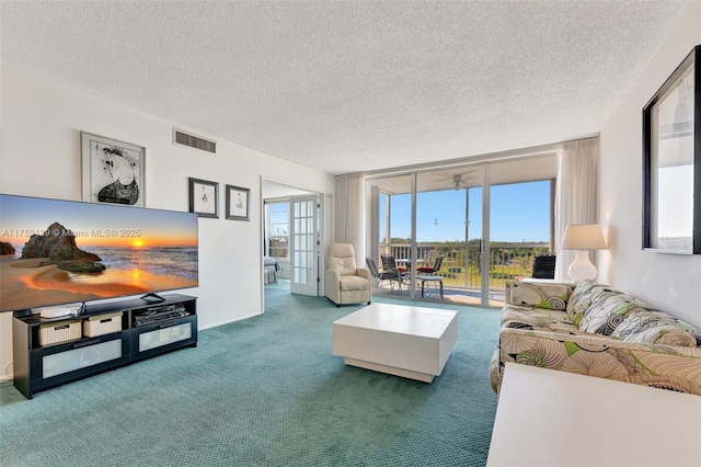 carpeted living area with a wall of windows, visible vents, and a textured ceiling