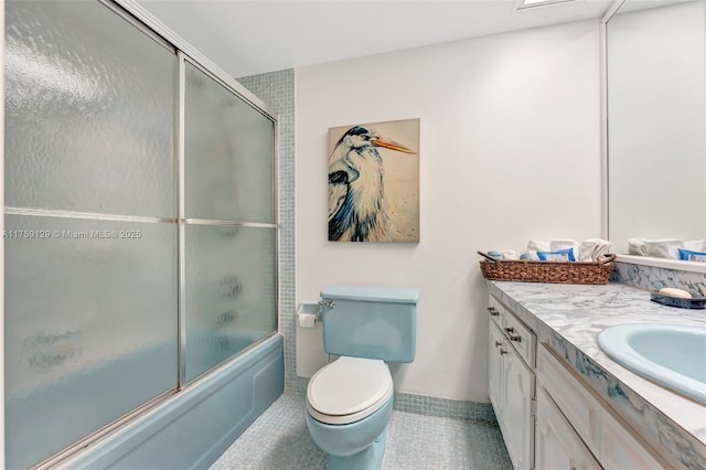 bathroom featuring toilet, tile patterned floors, combined bath / shower with glass door, and vanity