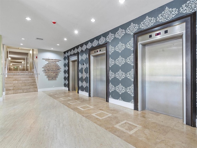 interior space featuring wallpapered walls, elevator, and stairs