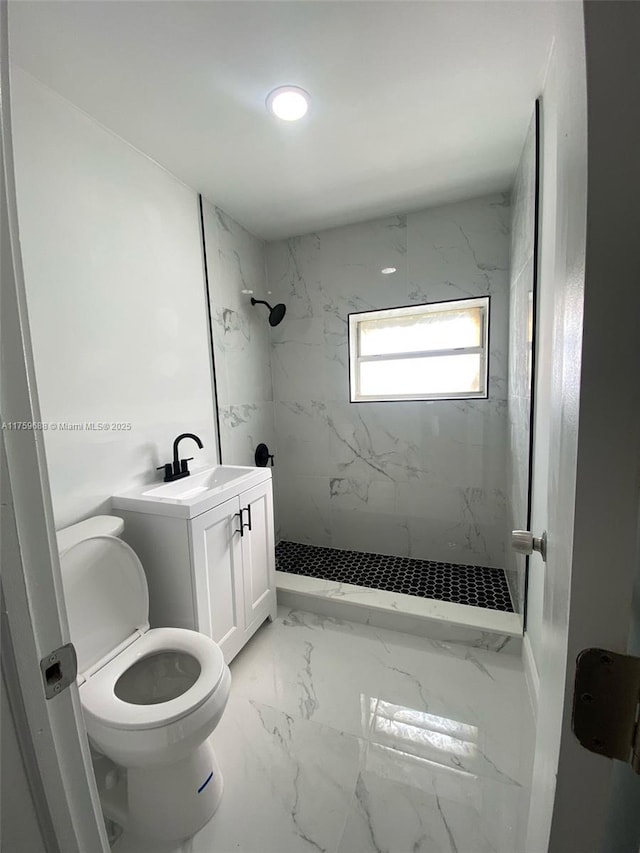 bathroom featuring vanity, toilet, marble finish floor, and a marble finish shower