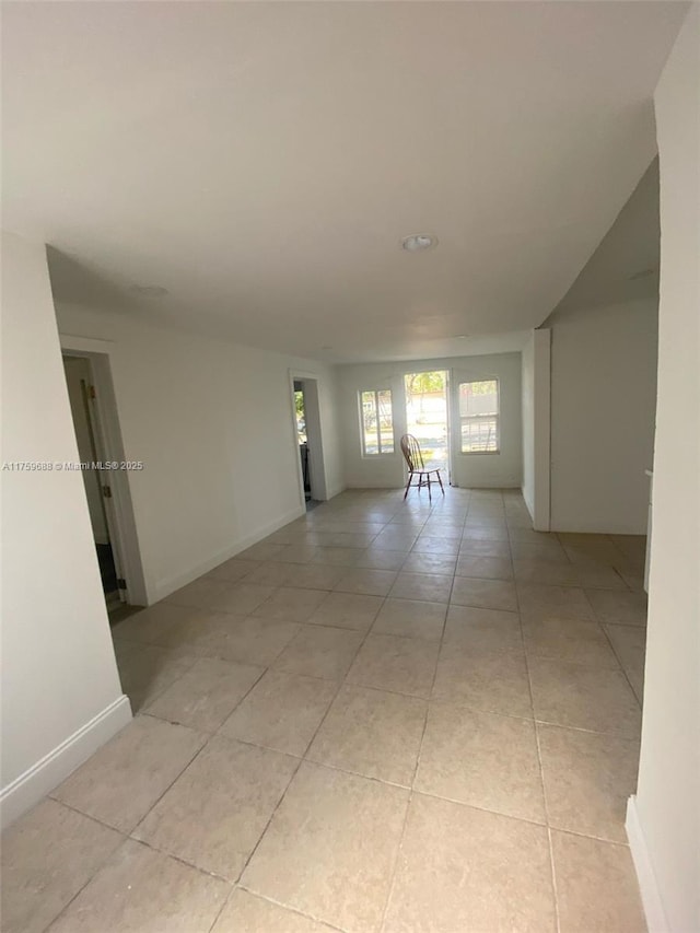 spare room featuring baseboards and light tile patterned flooring