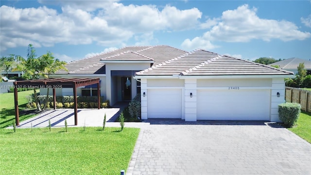 view of front of home with a front lawn, a tile roof, decorative driveway, fence, and a garage