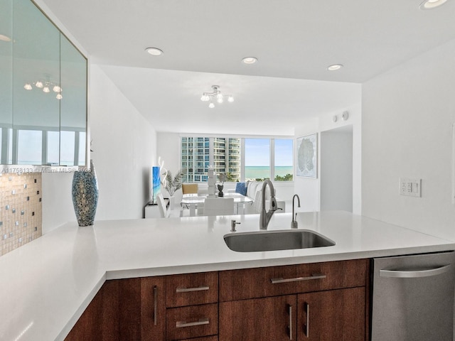 kitchen featuring recessed lighting, light countertops, dark brown cabinetry, a sink, and dishwasher