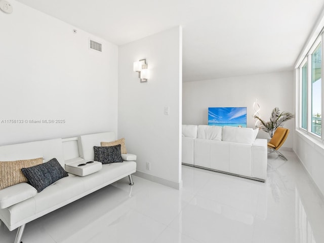 living area with baseboards and visible vents