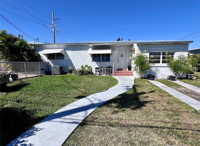 view of front of property featuring central air condition unit, fence, a front lawn, and stucco siding