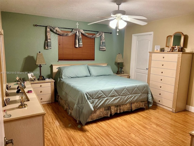 bedroom featuring a textured ceiling, light wood-style flooring, and a ceiling fan