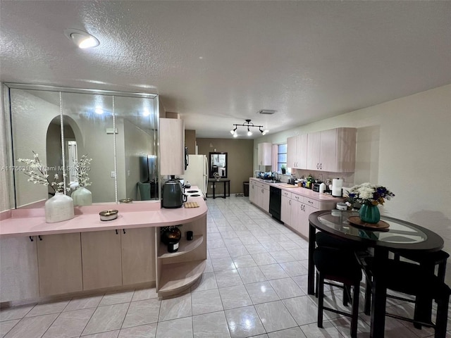 kitchen with black dishwasher, light countertops, open shelves, and freestanding refrigerator