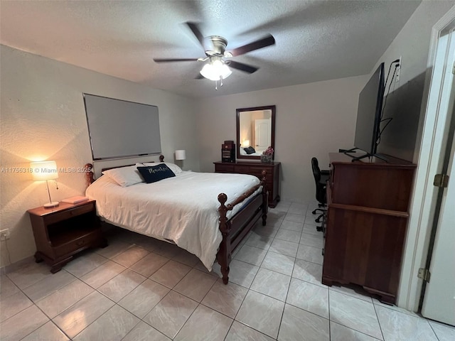 bedroom featuring light tile patterned floors, ceiling fan, and a textured ceiling