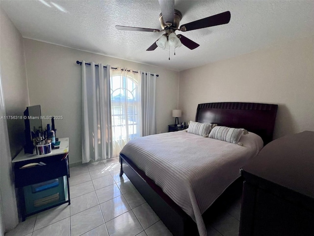 bedroom featuring ceiling fan, a textured ceiling, and light tile patterned flooring