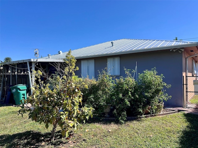 rear view of property with metal roof and stucco siding