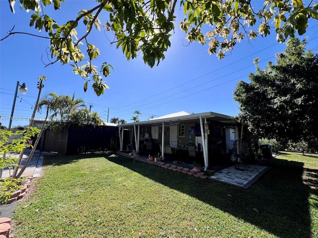 view of yard with a patio area, fence, and a sunroom