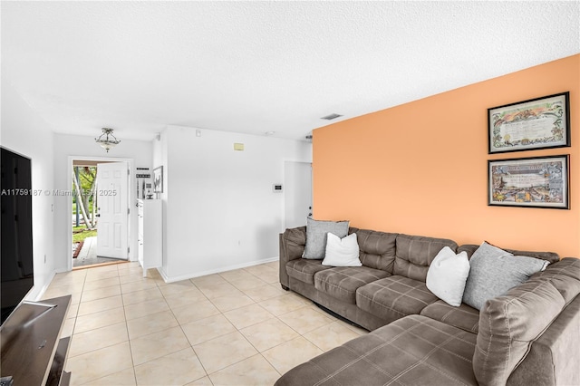 living room featuring light tile patterned floors, baseboards, visible vents, and a textured ceiling