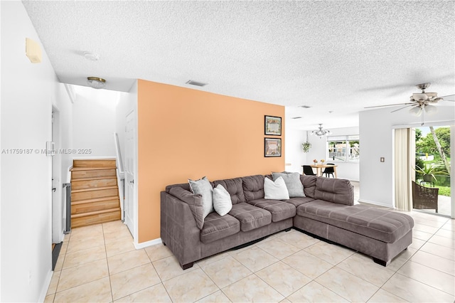 living room with light tile patterned floors, stairs, visible vents, and a textured ceiling