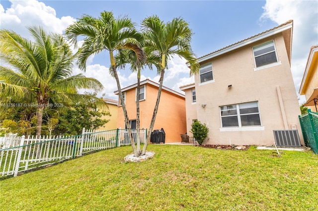 back of property featuring a yard, a fenced backyard, cooling unit, and stucco siding