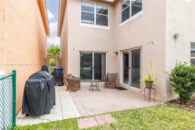 back of property featuring fence, a patio, and stucco siding