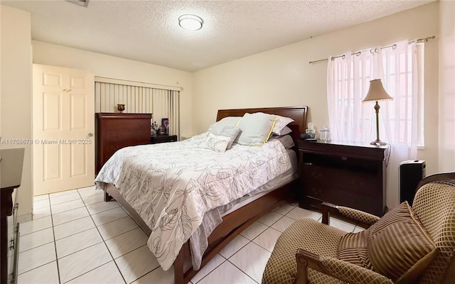 bedroom with light tile patterned floors and a textured ceiling