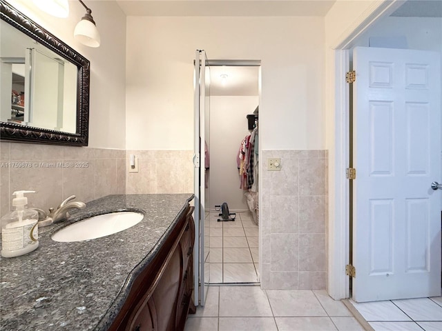 bathroom featuring tile patterned floors, tile walls, and vanity